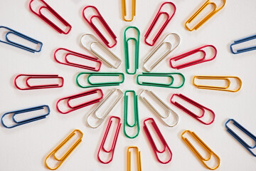 白い紙の上にたくさんのカラフルなクリップ