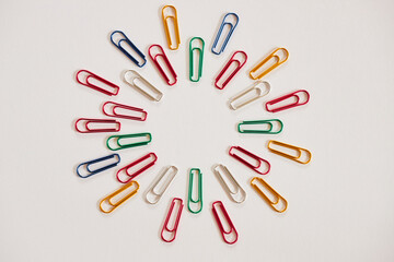 白い紙の上にたくさんのカラフルなクリップ