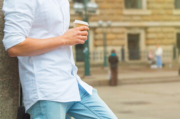 Man taking a break and drinking a take away coffee cup in the street.