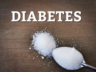 Selective focus image with noise effect wooden background with text DIABETES and a spoon of...