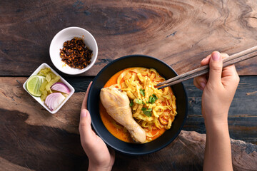 Northern Thai food (Khao Soi), Spicy curry noodles soup with chicken eating with crispy deep-fried...