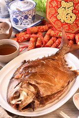 Smoked golden pomfret on white plate. (the Chinese words is 'make money, lucky', not a logo or trademark.)   