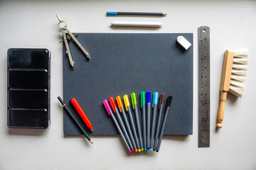 Notebook with colorful art supplies over a clear background
