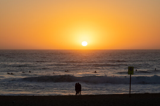 Silhouette of couple at the beach watching the sunrise