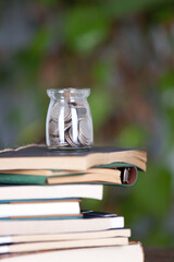 A stack of books and a glass of coins