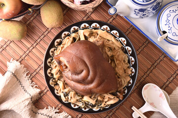 Stewed pork trotters with bamboo shoots in brown sauce on the plate 