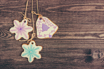 Gingerbread cookies hanging over wooden background. Copy space.