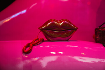 Glamorous red lips shaped corded retro phone on bright vivid pink background. Fashion beauty vintage pop art concept, Valentine's day, lover, copy space