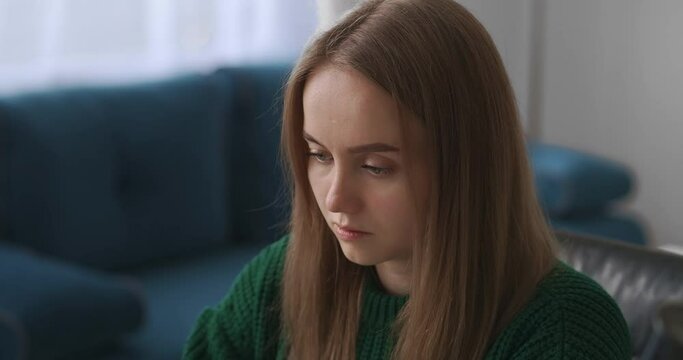 young pretty woman is working in office, typing text on keyboard of laptop, closeup of face and hands in workroom