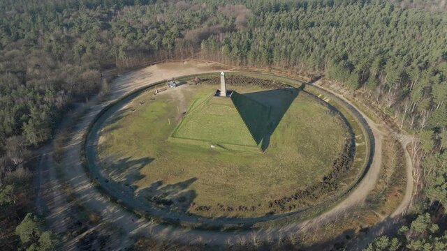 Aerial of Austerlitz Pyramid in the Netherlands on a sunny day - revealing beautiful surrounding forest. The Piramide van Austerlitz is a monument, built in 1804 as a tribute to Napoleon Bonaparte.