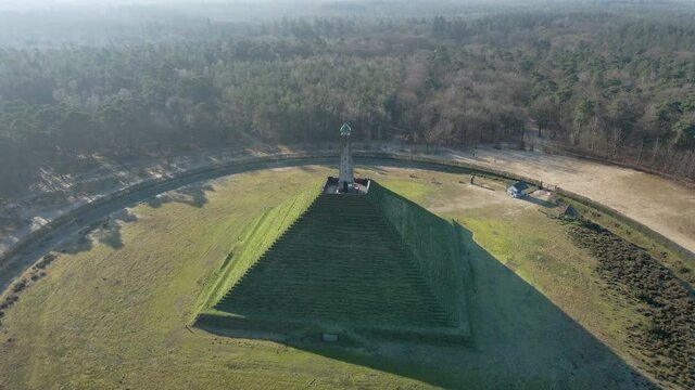 Stunning aerial of Austerlitz pyramid in the Netherlands. Drone flying backwards revealing beautiful forest. The Piramide van Austerlitz is a monument built in 1804 as a tribute to Napoleon Bonaparte.