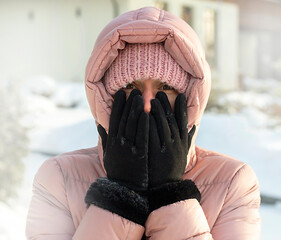 girl in a pink down jacket in the bitter cold in winter, frozen face