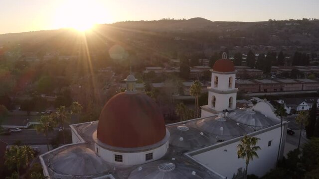 Sunset aerial view of the Spanish Colonial era mission and surrounding city of downtown San Juan Capistrano, California, USA. 