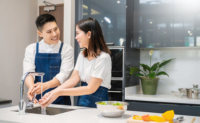 Portrait of asian couple man woman washing hands rubbing with soap for corona virus prevention in kitchen under water sink tap for cooking, hygiene to stop spreading coronavirus concept banner