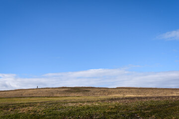 Fototapeta na wymiar Wide angle shot of a man walking across a field.