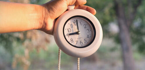 Man hand holding alarm clock showing nine o'clock time concept to start a new day.