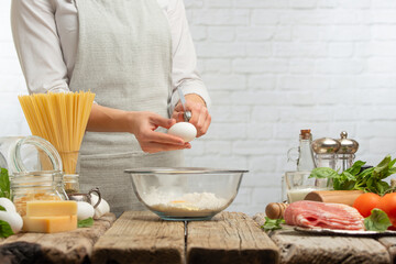Cook prepares dough with flour, light kitchen background.Cooking pasta, bread flour and pizza.Culinary recipes