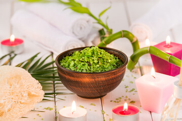 Spa. Green herbal spirulina salt in ceramic bowl, spa towels, pink scented candle and bamboo. Toned, matte