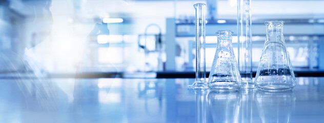 shadow of scientist and glass flask and cylinder in medical science lab blue banner background