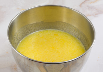 Sweet lemon mix for dessert bars in stainless steel mixing bowl on kitchen counter