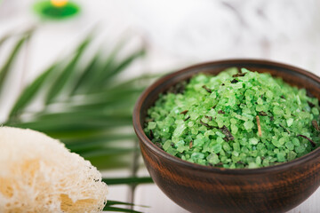 Spa. Green herbal spirulina salt in ceramic bowl, spa towels, candles and bamboo