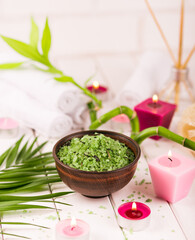 Obraz na płótnie Canvas Spa. Green herbal spirulina salt in ceramic bowl, spa towels, pink scented candle and bamboo