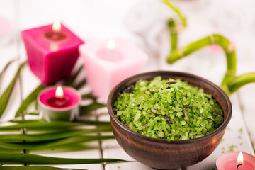 Obraz na płótnie Canvas Spa. Green herbal spirulina salt in ceramic bowl, spa towels, pink scented candle and bamboo