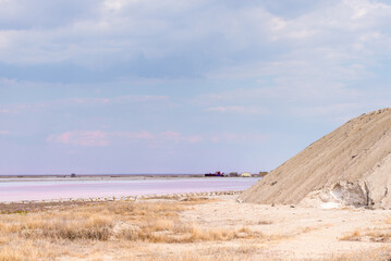 People gathering salt of pink salty Siwash Lake, colored by microalgae, famous for antioxidant properties, enriching water by beta-carotene at sunset