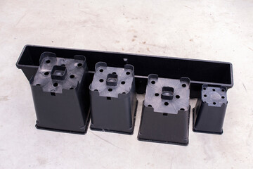 Group of Different shape and size black plastic plant pots.