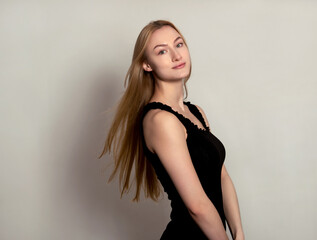 Fototapeta premium Beautiful young woman with long shiny and healthy blonde hair posing on grey background