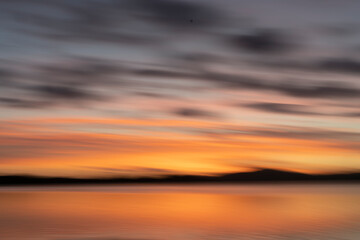 Golden hour morning light over Waimapu Estuary bay motion blur abstract.