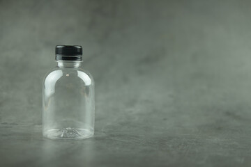 Empty clear plastic bottle with black lid