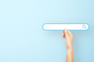 Hand holding paper with search bar on light blue background. Concept of searching information data on internet networking - obrazy, fototapety, plakaty