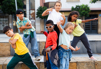 Smiling girls and boys hip hop dancers doing dance workout during open air group class