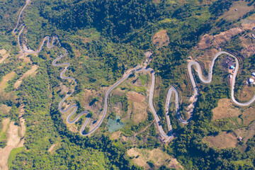 Aerial view of cars driving on curved, zigzag curve road or street on mountain hill with green...