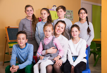 Portrait of elementary age children with teacher sitting in classroom