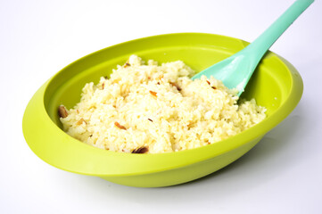 An image of simple fried rice or Nasi Goreng in  a green bowl over white background. Famous Asian food.