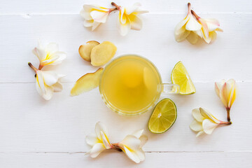herbal healthy drinks ginger ,lemon cocktail water with flower frangipani arrangement  flat lay style on background white 