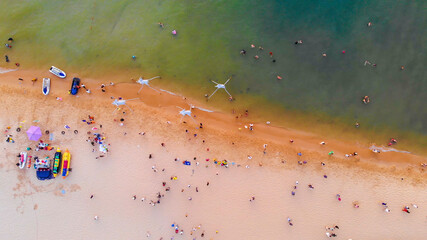 Fototapeta na wymiar Aerial view of Sunset in Phu Quoc beach with nice view. Tourists, sunbeds and umbrellas on beautiful day in Sanato beach, Phu Quoc island, Vietnam