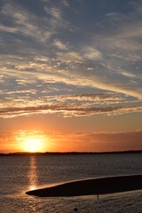 Fototapeta premium sunset over quiet bay with sand island in the foreground, portrait format