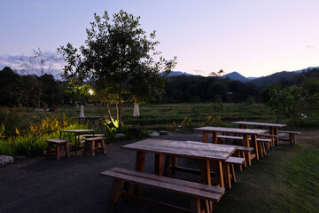 Fototapeta premium Outdoor terrace patio with natural landscape of rice paddy field and green mountain range with clear blue sky