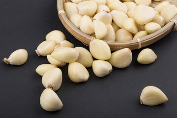 Pile of peeled garlics on black background isolated.