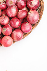 Red onions in wooden basket on white background
