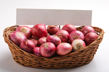 Red onions in wooden basket on white background