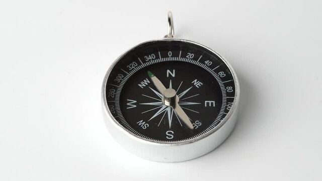 Close up shot of a spinning vintage compass isolated on white background.