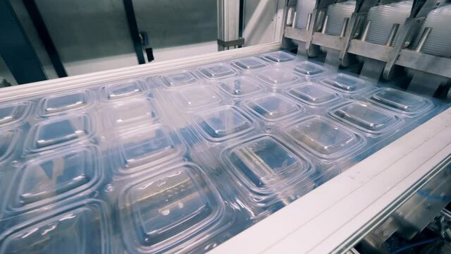 Plastic package material is moving through the conveyor