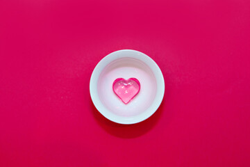 cup with hearts on a red background. the view from the top. red hearts spilled out. isolated on a pink background. copy space