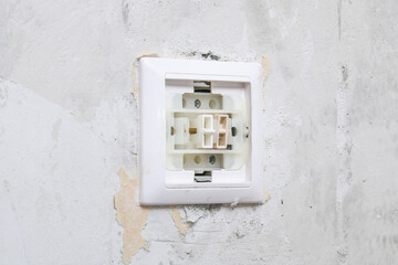 A worker removes the light switch for wallpapering.