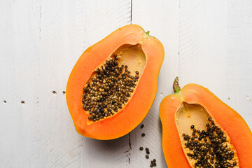 Ripe papaya on a white wooden background,Papaya cut in half