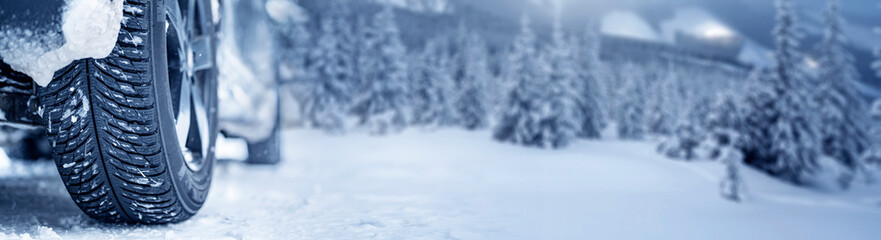 Winter tire. Detail of car tires in winter on the road covered with snow. Panorama, banner